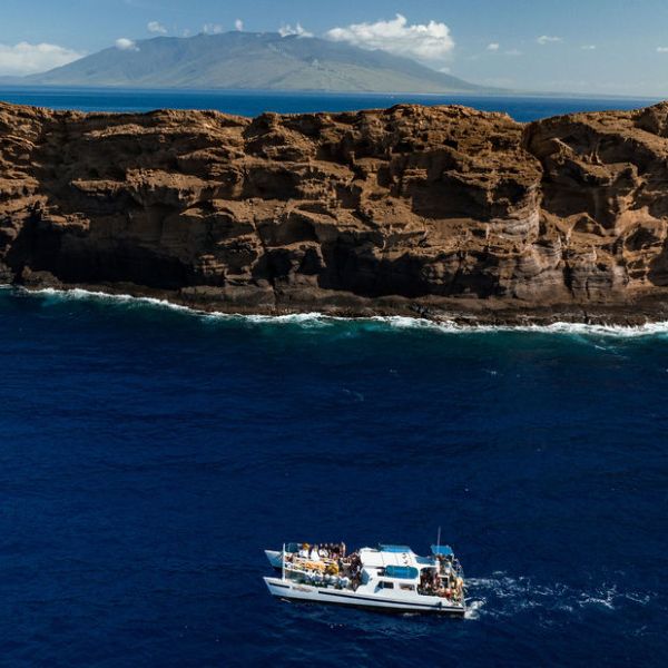 a small boat in a body of water with a mountain in the background