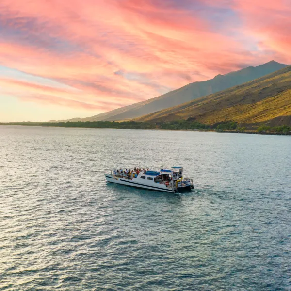 a small boat in a body of water with a mountain in the background